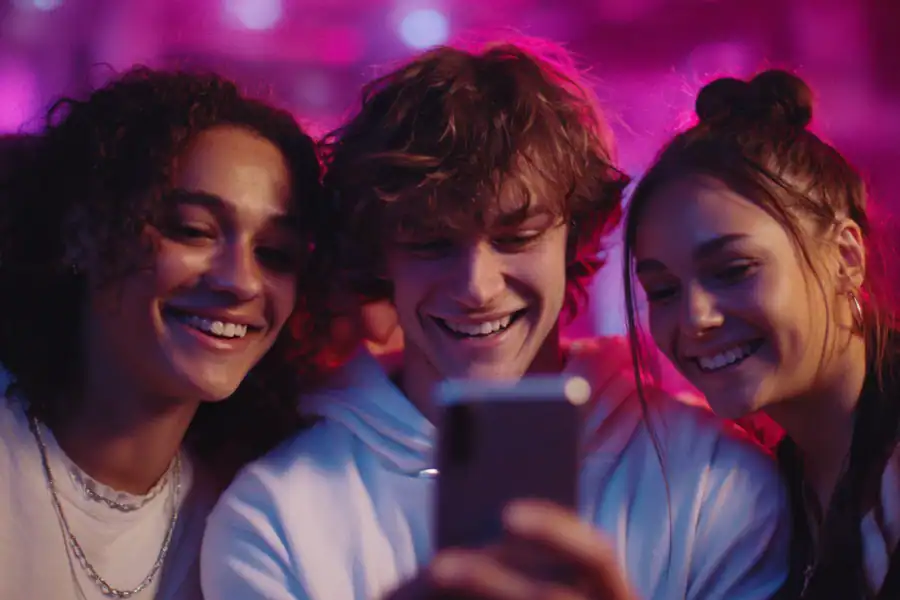 Vibrant group of friends smiling and taking a selfie at a lively party scene.