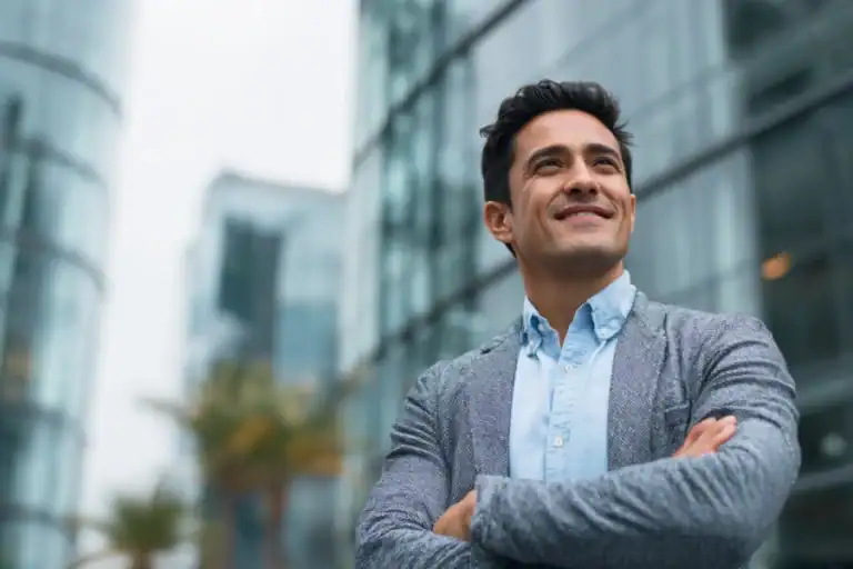Confident businessman smiling outdoors in modern urban setting, professional success, executive, corporate leader, cityscape, skyscrapers.